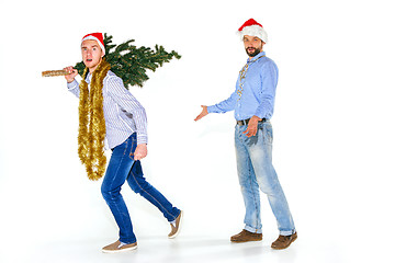 Image showing The young man in Santa cap carrying Christmas tree