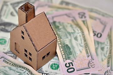 Image showing Miniature paper made house stand on  money