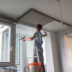 Image showing Plasterer renovating indoor walls and ceilings. Construction finishing works.