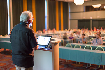 Image showing Senior public speaker giving talk at scientific conference.