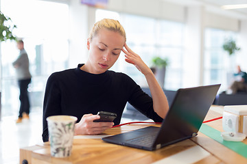 Image showing Female freelancer remotely working on the go.