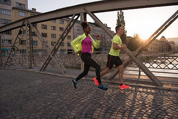 Image showing young multiethnic couple jogging in the city