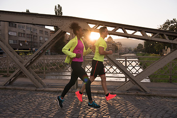 Image showing young multiethnic couple jogging in the city