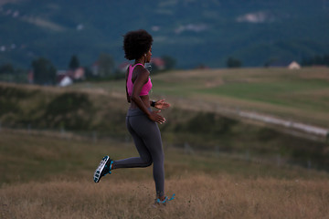 Image showing Young African american woman jogging in nature