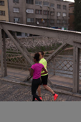 Image showing young multiethnic couple jogging in the city