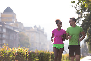 Image showing young multiethnic couple jogging in the city