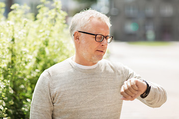 Image showing senior man checking time on his wristwatch