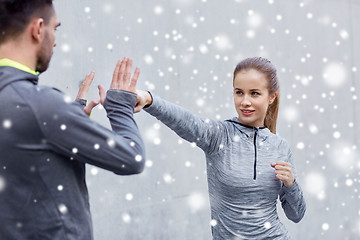 Image showing happy woman with coach working out strike outdoors