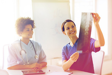 Image showing happy female doctors with x-ray image at hospital