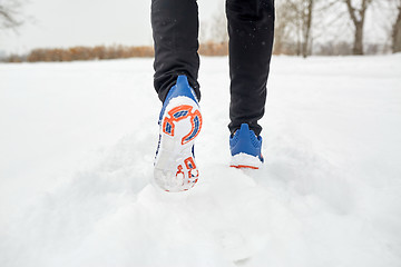 Image showing close up of feet running along snowy winter road