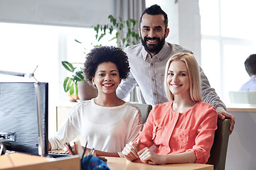 Image showing happy creative team with computer in office