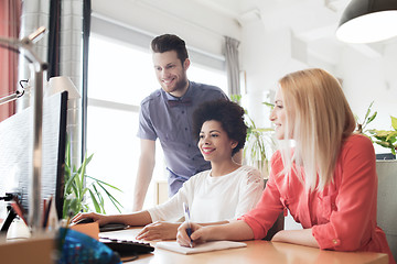 Image showing happy creative team with computer in office