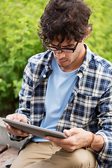 Image showing man in glasses with tablet pc computer outdoors