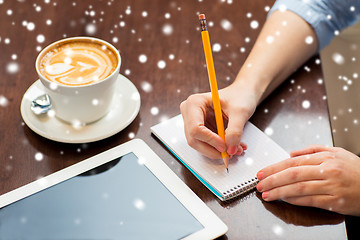 Image showing close up of woman writing to notebook with pencil