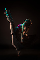 Image showing Young beautiful dancer in beige dress dancing on black background