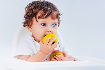 Image showing Happy baby boy sitting and eating