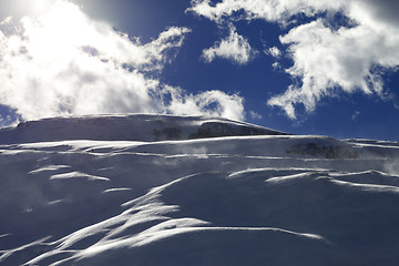 Image showing Off-piste slope during blizzard and sunlight blue sky with cloud