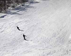 Image showing Snowboarders on ski slope at sun winter day