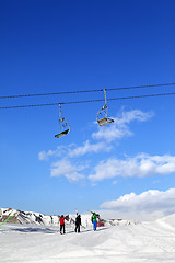 Image showing Three skiers on slope at sun winter day