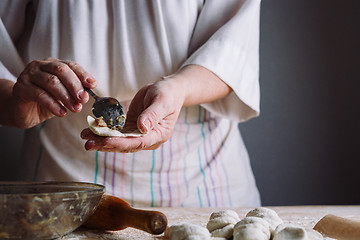 Image showing Two hands making meat dumplings.