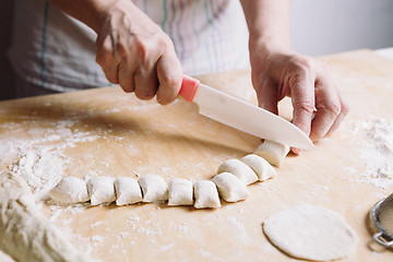 Image showing Two hands making dough for meat dumplings.