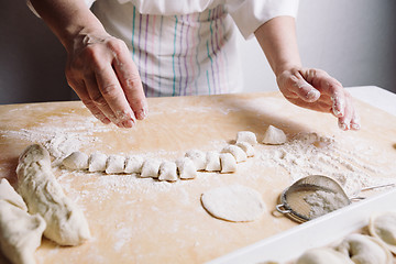 Image showing Two hands making dough for meat dumplings.