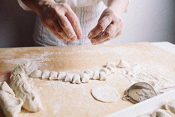 Image showing Two hands making dough for meat dumplings.