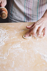 Image showing Two hands making dough for meat dumplings.