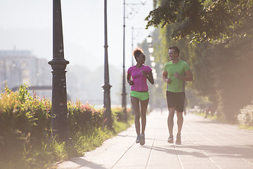 Image showing young multiethnic couple jogging in the city