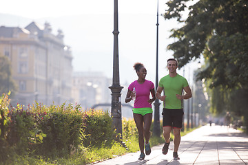 Image showing young multiethnic couple jogging in the city