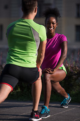 Image showing jogging couple warming up and stretching in the city
