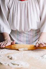 Image showing Making meat dumpling with wooden rolling pin.