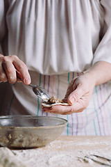 Image showing Two hands making meat dumplings.