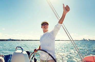 Image showing senior man at helm on boat or yacht sailing in sea