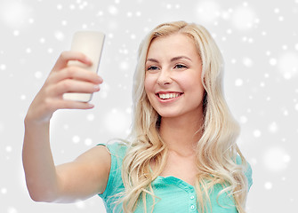 Image showing smiling young woman taking selfie with smartphone