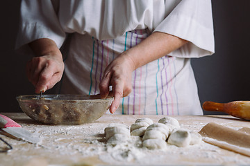 Image showing Two hands making meat dumplings.