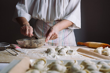 Image showing Two hands making meat dumplings.
