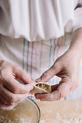 Image showing Two hands making meat dumplings.