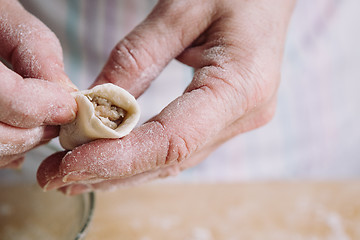 Image showing Two hands making meat dumplings.