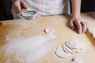 Image showing Two hands making dough for meat dumplings.