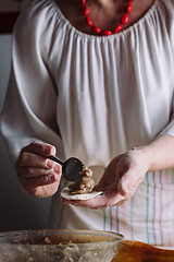 Image showing Two hands making meat dumplings.