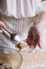 Image showing Two hands making meat dumplings.