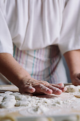 Image showing Two hands making dough for meat dumplings.