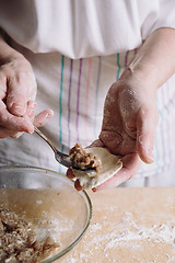 Image showing Two hands making meat dumplings.