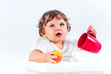 Image showing Happy baby boy sitting and eating