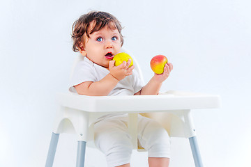 Image showing Happy baby boy sitting and eating