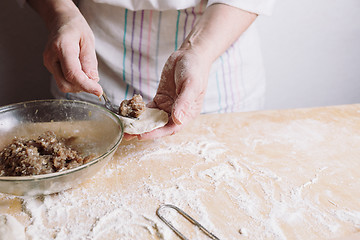 Image showing Two hands making meat dumplings.