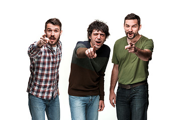 Image showing The three men are smiling, looking and pointing at camera