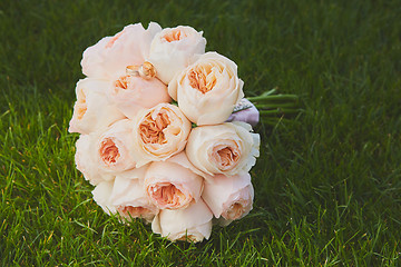 Image showing wedding bouquet of the bride at the grass.