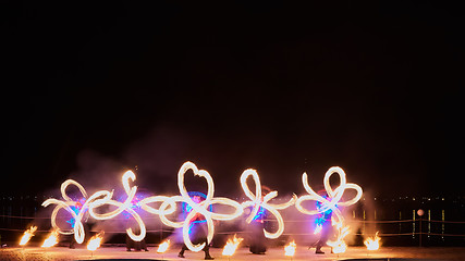 Image showing Artists juggling with burning poi\'s at fire performance.